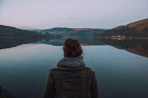 Woman silently looking at a lake